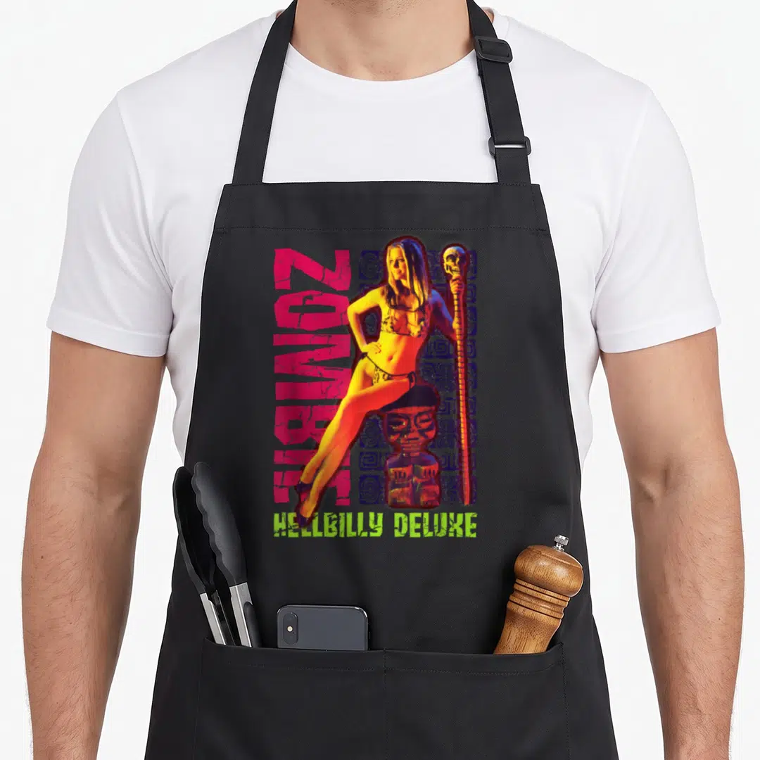 Rob stone apron - Vertical ZOMBIE text, woman on tiki statue, skull staff, Hellbilly Deluxe bottom — shown on a black cotton canvas apron against a white background