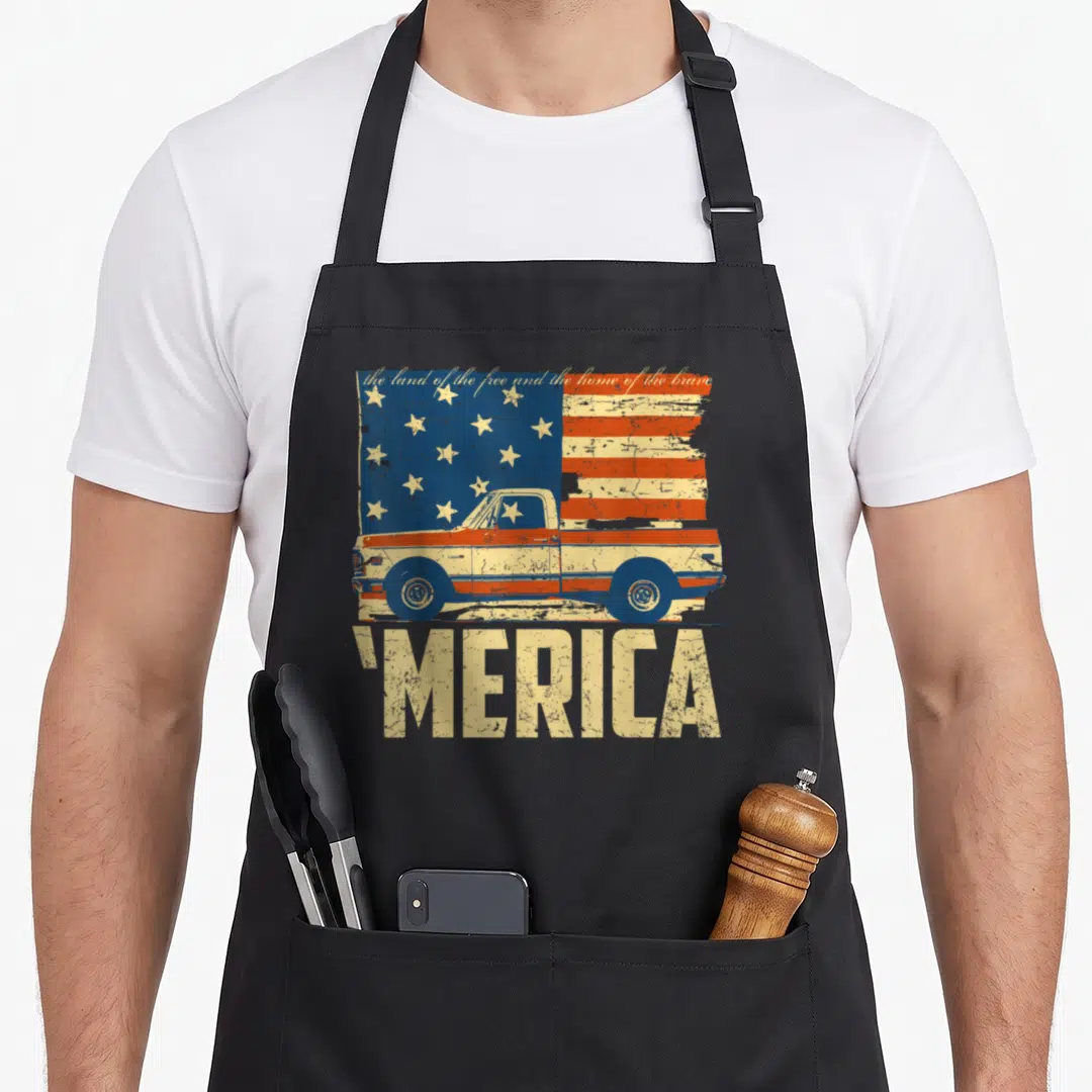 Merica american flag apron - Distressed US flag with vintage pickup truck overlay, script text above, 'MERICA below — shown on a black cotton canvas apron against a white background