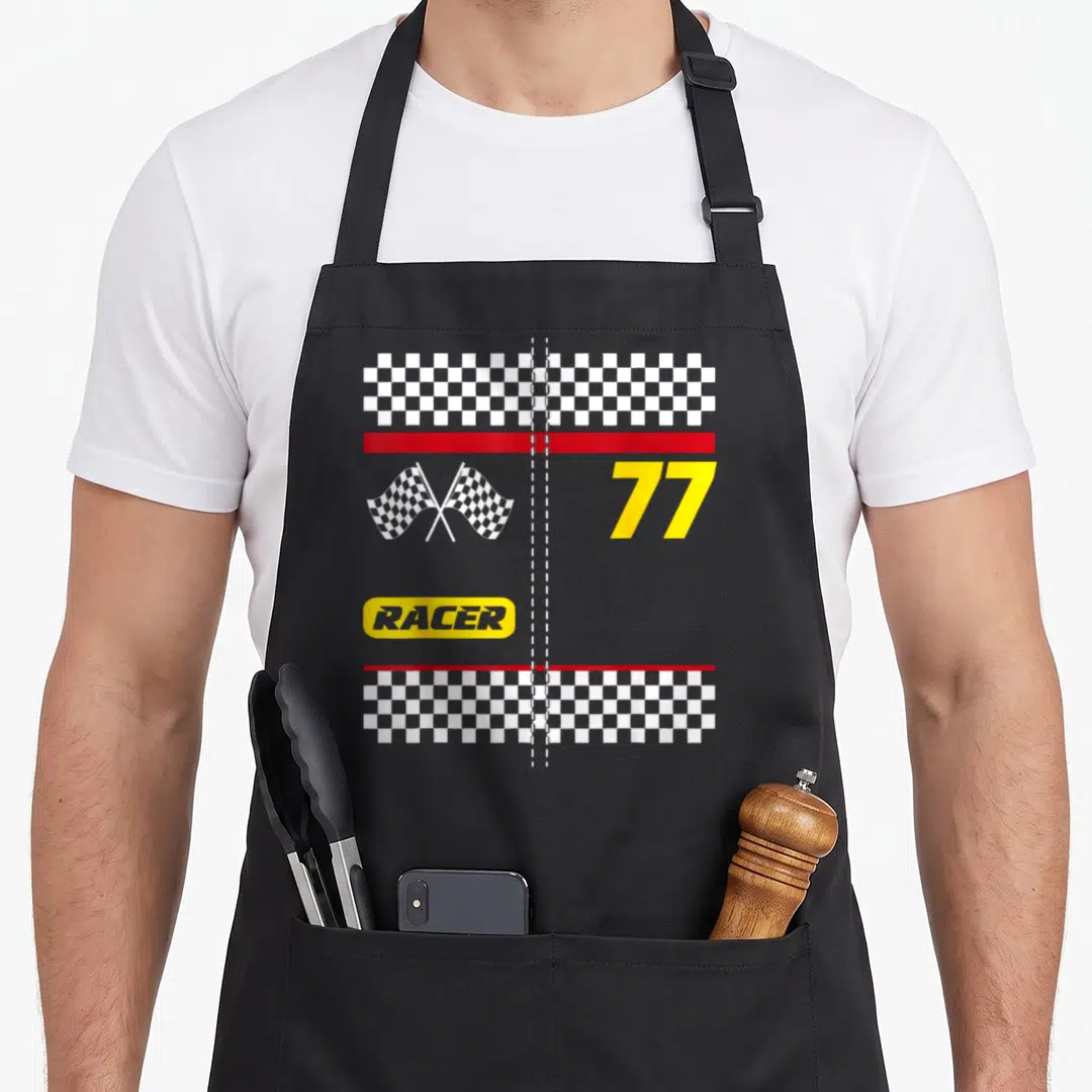 Wowsome funny halloween apron - Racing number 77 with crossed checkered flags and RACER text in yellow oval — shown on a black cotton canvas apron against a white background