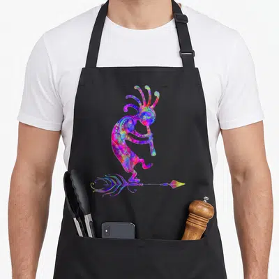 Kokopelli native american apron - Tie-dye Kokopelli figure above feathered arrow in blue pink yellow green purple — shown on a black cotton canvas apron against a white background