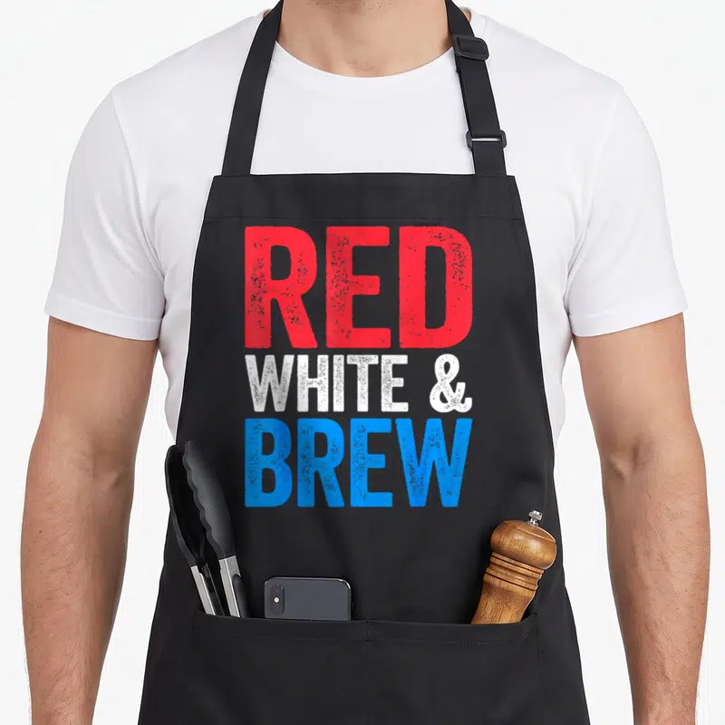 Brew fourth of july aprons - Stacked text reading RED WHITE & BREW in red, white, and blue block letters — shown on a black cotton canvas apron against a white background