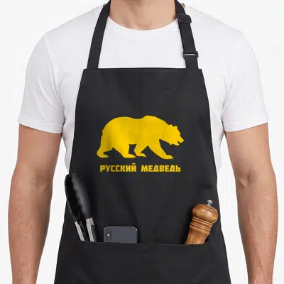 Bear russian apron - Yellow bear silhouette above Cyrillic text reading Russian Bear — shown on a black cotton canvas apron against a white background