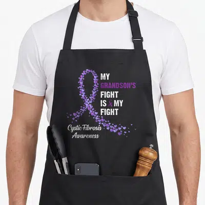 Grandson cystic fibrosis awareness apron - Purple heart ribbon and My Grandson's Fight Is My Fight text in white — shown on a black cotton canvas apron against a white background