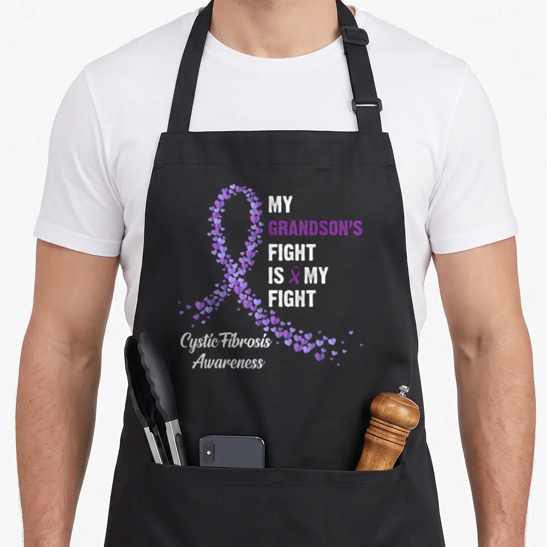Grandson cystic fibrosis awareness apron - Purple heart ribbon and My Grandson's Fight Is My Fight text in white — shown on a black cotton canvas apron against a white background