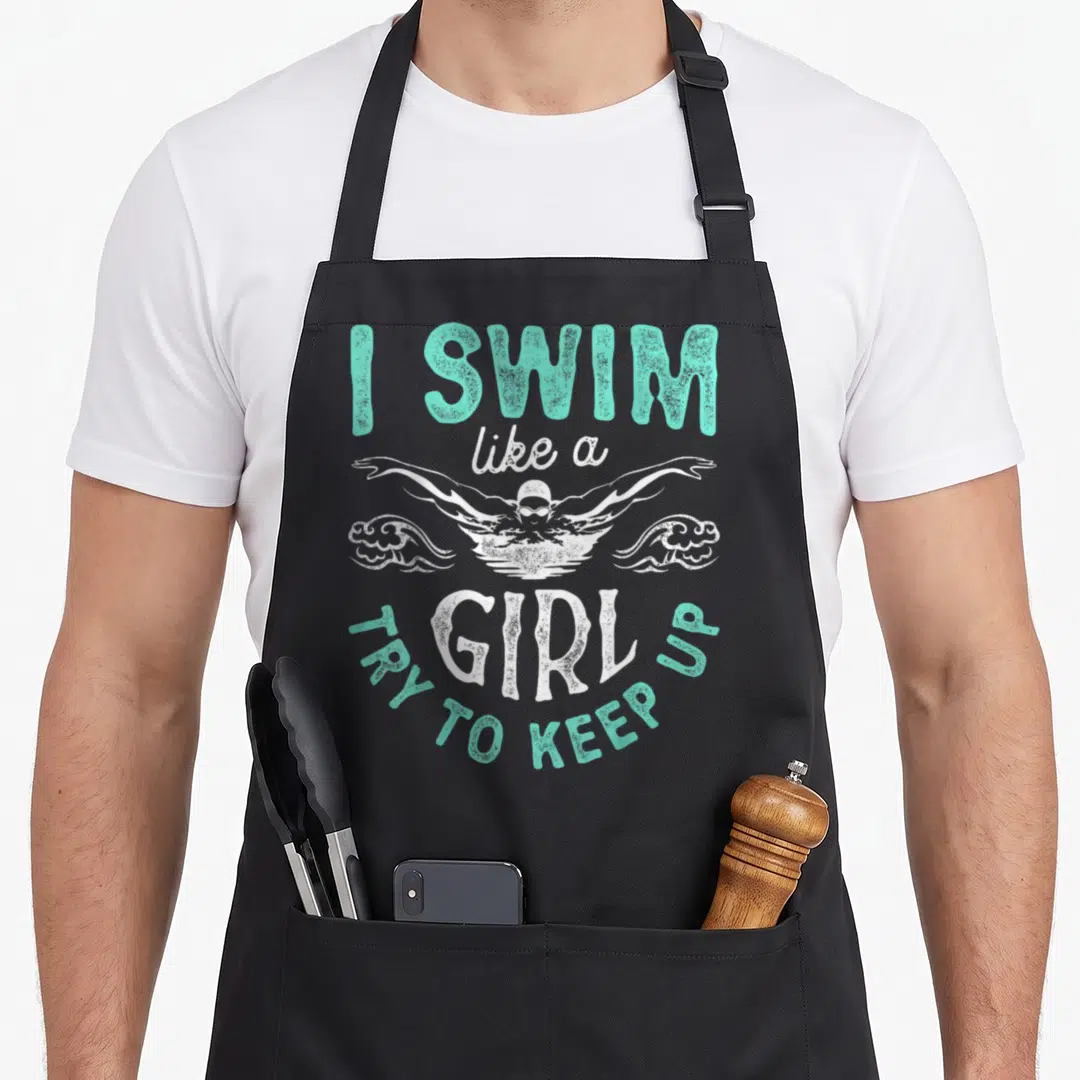 Try i love swimming apron - Teal and white distressed text I swim like a girl with swimmer illustration — shown on a black cotton canvas apron against a white background