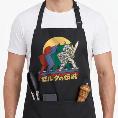 Link legend apron - Retro Link silhouettes in red blue green yellow with Japanese text on striped bar — shown on a black cotton canvas apron against a white background