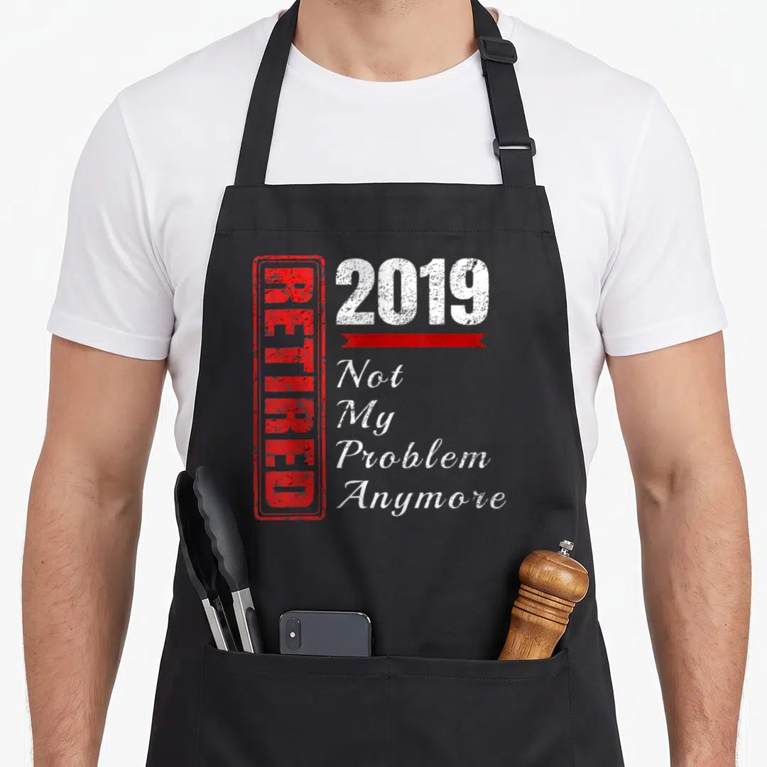 Problem funny retirement aprons - Red vertical stamp reading RETIRED next to white 2019 and stacked text Not My Problem — shown on a black cotton canvas apron against a white background