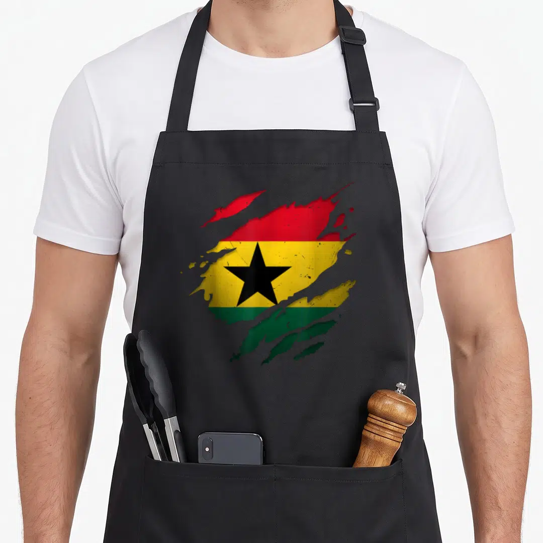 Ghanaian torn apron - Torn flag art in red yellow green and black with central star on grey background — shown on a black cotton canvas apron against a white background