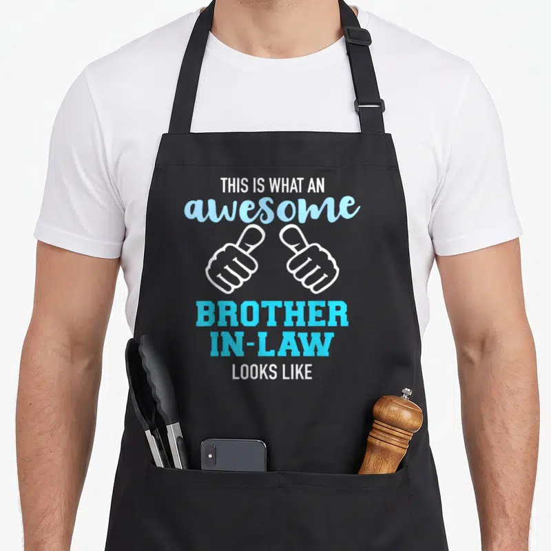 Cute brother in law apron - Two white thumbs up icons with stacked blue and white text reading awesome brother in law — shown on a black cotton canvas apron against a white background
