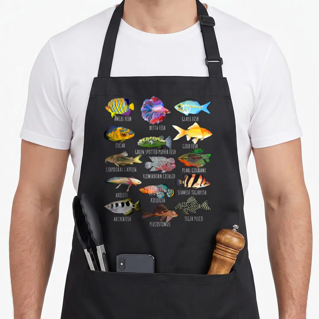 Fishkeeping fish apron - Grid of 15 labeled aquarium fish including Oscar, Betta, and Tiger Pleco in realistic art style — shown on a black cotton canvas apron against a white background