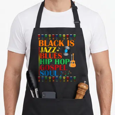 Music african american aprons - Stacked BLACK IS JAZZ BLUES HIP HOP GOSPEL SOUL text with djembe drum borders and vinyl — shown on a black cotton canvas apron against a white background