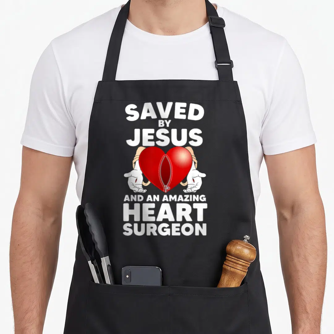 Surgery patient open apron - Red heart with zipper held by two hands surrounded by white text — shown on a black cotton canvas apron against a white background