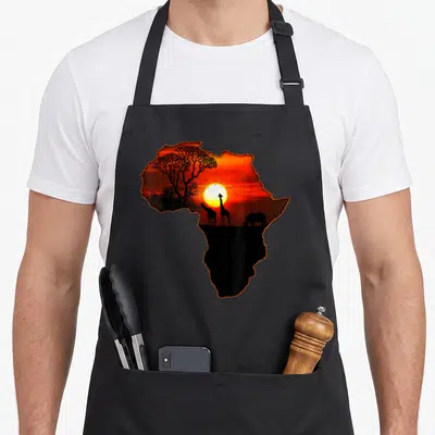 Map south african apron - African continent silhouette containing a sunset with giraffes, rhino, birds, and baobab tree — shown on a black cotton canvas apron against a white background