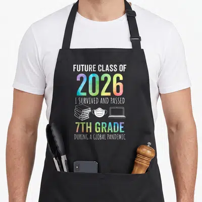 7th future class apron - FUTURE CLASS OF 2026 text with books mask laptop icons in white and rainbow gradient — shown on a black cotton canvas apron against a white background