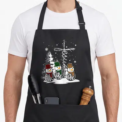Jesus xmas apron - Three snowmen in plaid and leopard hats with Faith Hope Love text and cross background — shown on a black cotton canvas apron against a white background