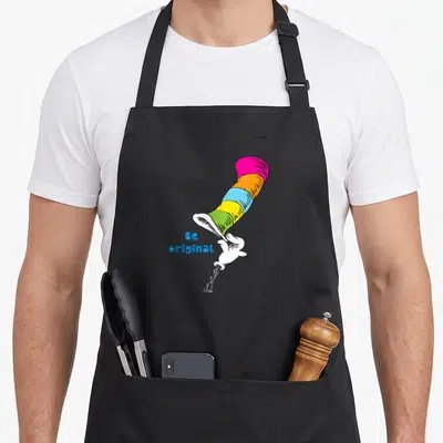 Original general apron - Multi-colored striped hat tipped by white glove with Be original text — shown on a black cotton canvas apron against a white background