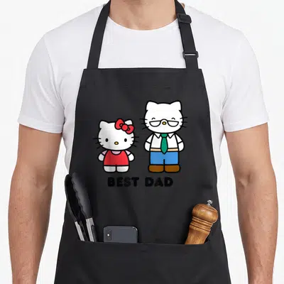 Cute father day apron - Two white cartoon cats standing side-by-side with BEST DAD text below — shown on a black cotton canvas apron against a white background