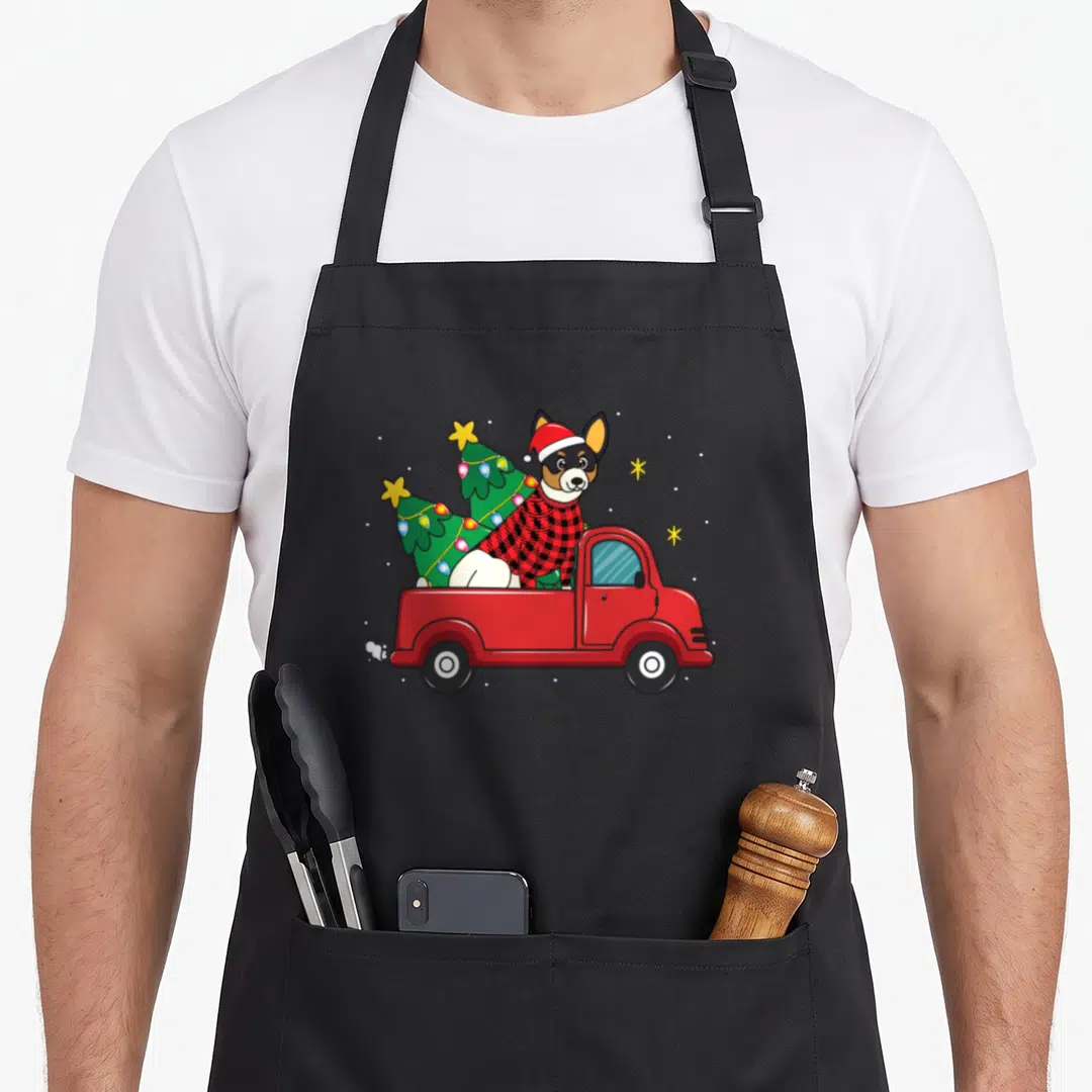 Rat christmas tree apron - Cartoon dog in red sweater and Santa hat sitting in red truck bed with two green Christmas — shown on a black cotton canvas apron against a white background