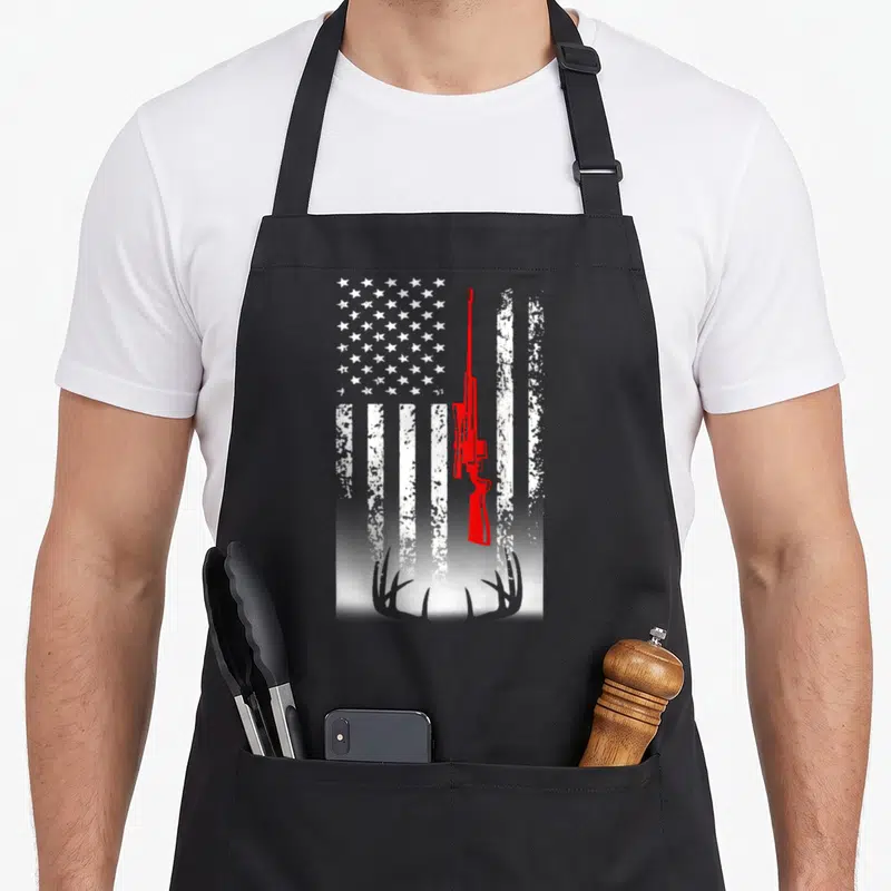 Hunting deer apron - Red rifle silhouette over distressed white flag stripes with grey antlers at bottom — shown on a black cotton canvas apron against a white background