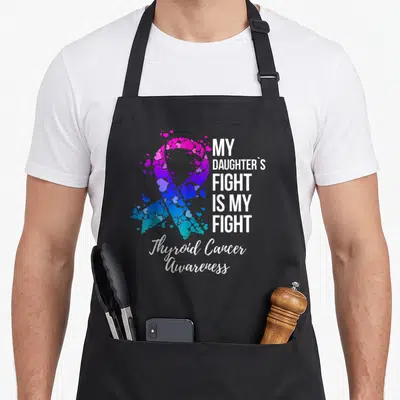 Fight thyroid apron - Heart mosaic awareness ribbon with stacked white text reading My Daughters Fight Is My Fight — shown on a black cotton canvas apron against a white background