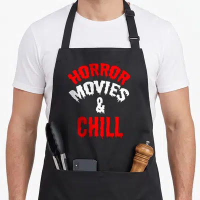 Chill horror apron - Dripping red and white text reading HORROR MOVIES & CHILL — shown on a black cotton canvas apron against a white background