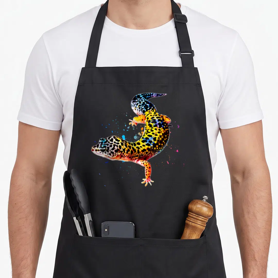 Gecko leopard apron - Watercolor leopard gecko in yellow orange blue and black with scattered paint splatters — shown on a black cotton canvas apron against a white background