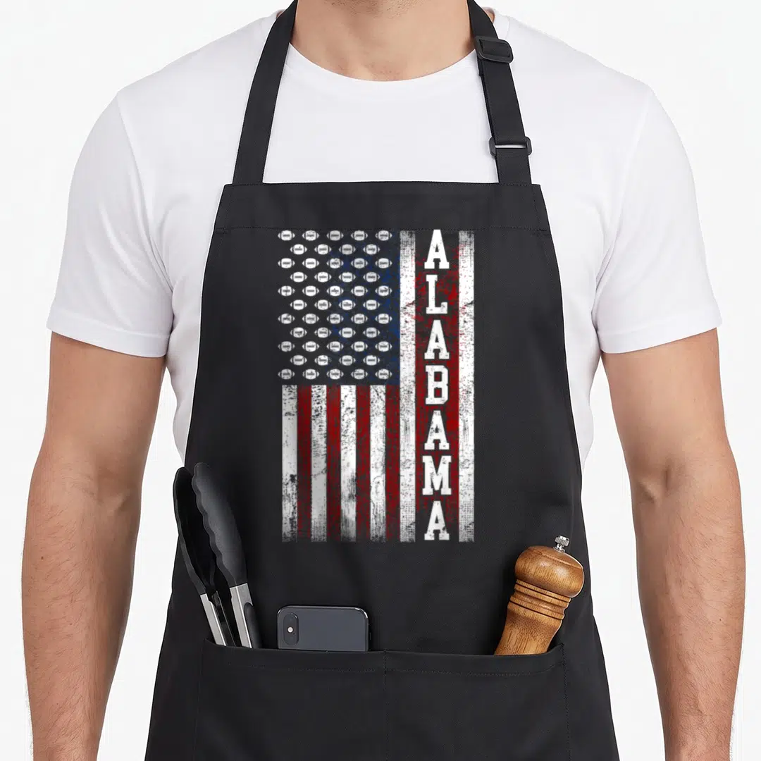 Alabama patriotic apron - Distressed USA flag with football canton and vertical ALABAMA text in red white blue — shown on a black cotton canvas apron against a white background