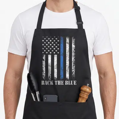 Thin blue american flag apron - Distressed white and blue flag with BACK THE BLUE text below — shown on a black cotton canvas apron against a white background