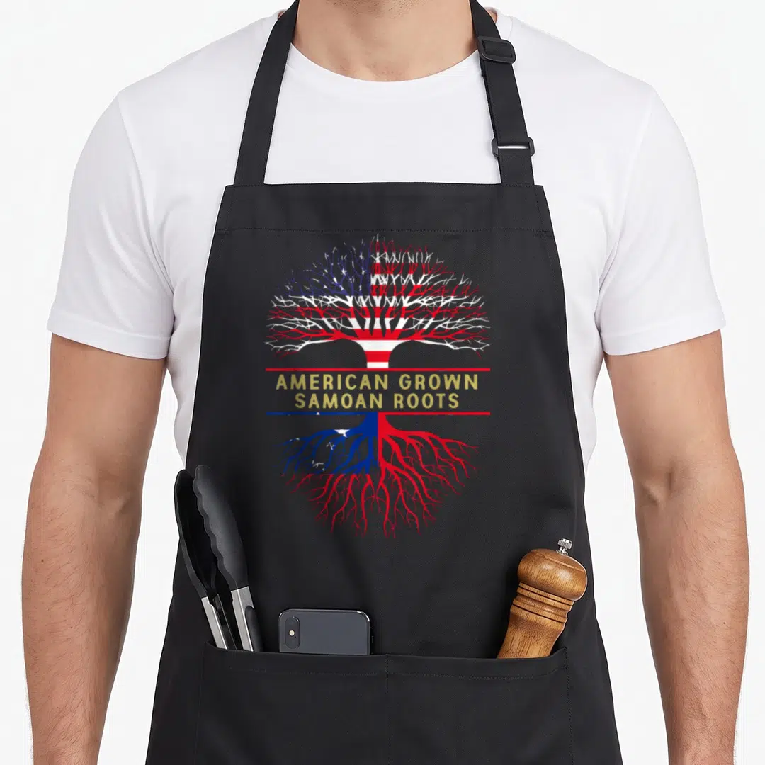 Grown samoan american flag apron - Tree with USA flag branches and Samoan flag roots and gold AMERICAN GROWN SAMOAN — shown on a black cotton canvas apron against a white background