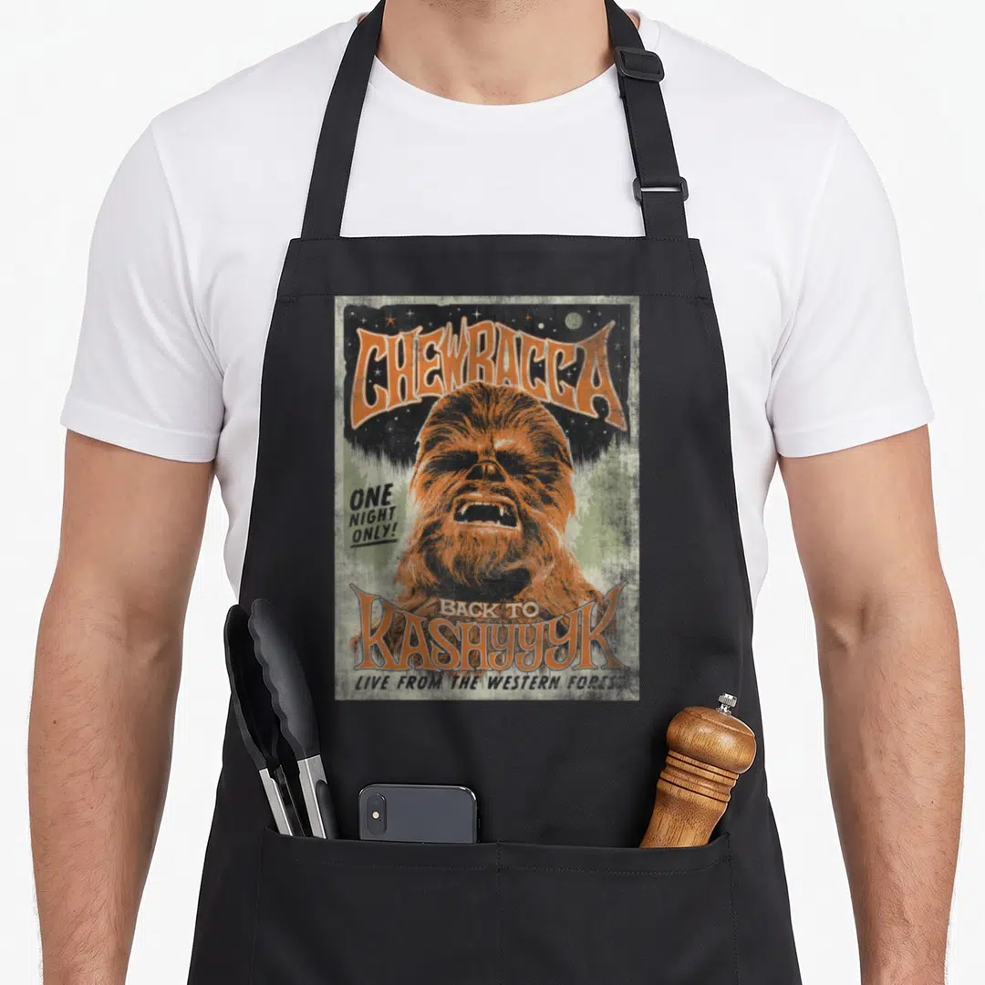 Funny kashyyyk concert apron - Retro concert poster design of Chewbacca with orange text and distressed green background — shown on a black cotton canvas apron against a white background