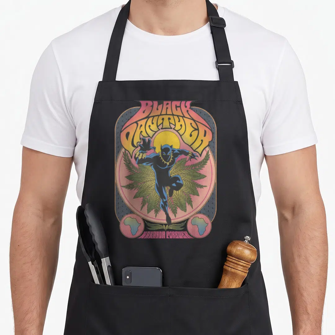Poster 70s apron - Retro Black Panther leaping before yellow sun and green leaves with Wakanda Forever text — shown on a black cotton canvas apron against a white background