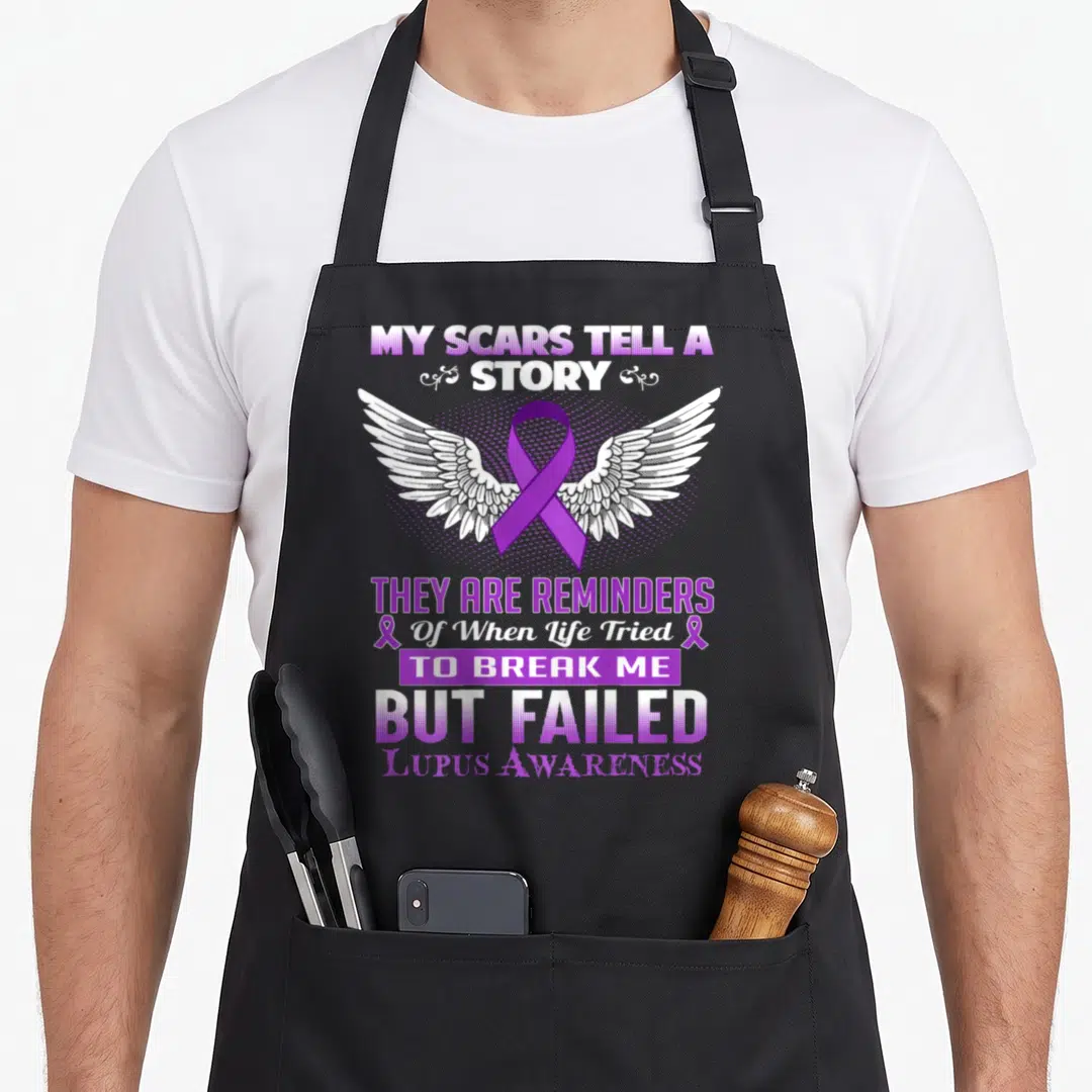 Scar story of the apron - Purple awareness ribbon with white wings and stacked text reading My Scars Tell A Story — shown on a black cotton canvas apron against a white background