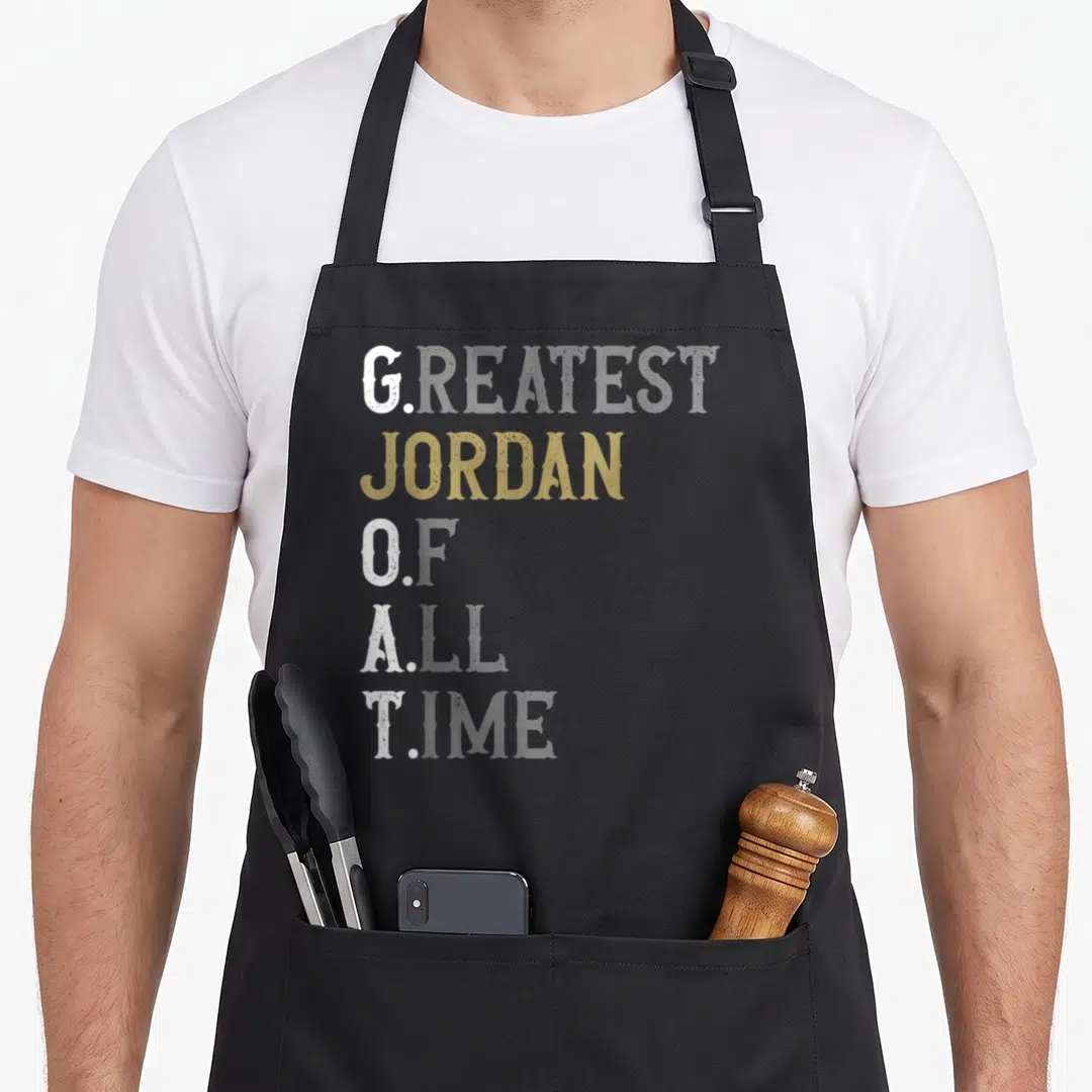 Greatest occasion goat apron - Stacked white and gold letters spelling G. Jordan O. A. T. on grey background — shown on a black cotton canvas apron against a white background