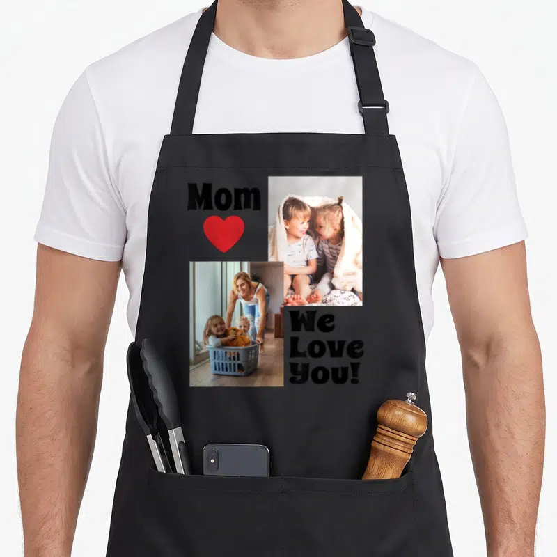 Personalize mother's day aprons - Photo collage of kids and laundry basket with Mom We Love You text and red heart — shown on a black cotton canvas apron against a white background