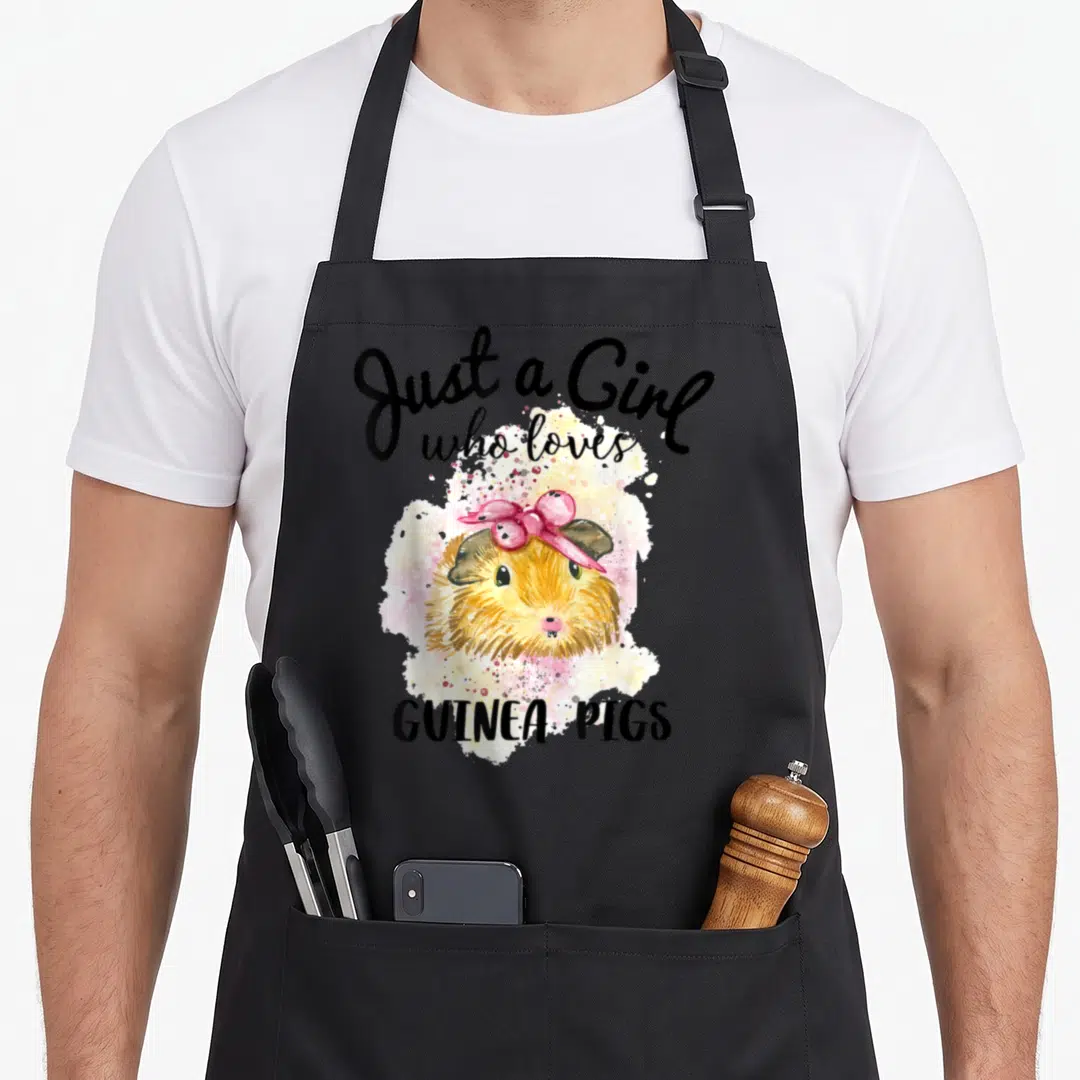 Guinea animal apron - Watercolor guinea pig with pink bow and text Just a Girl who loves Guinea Pigs — shown on a black cotton canvas apron against a white background
