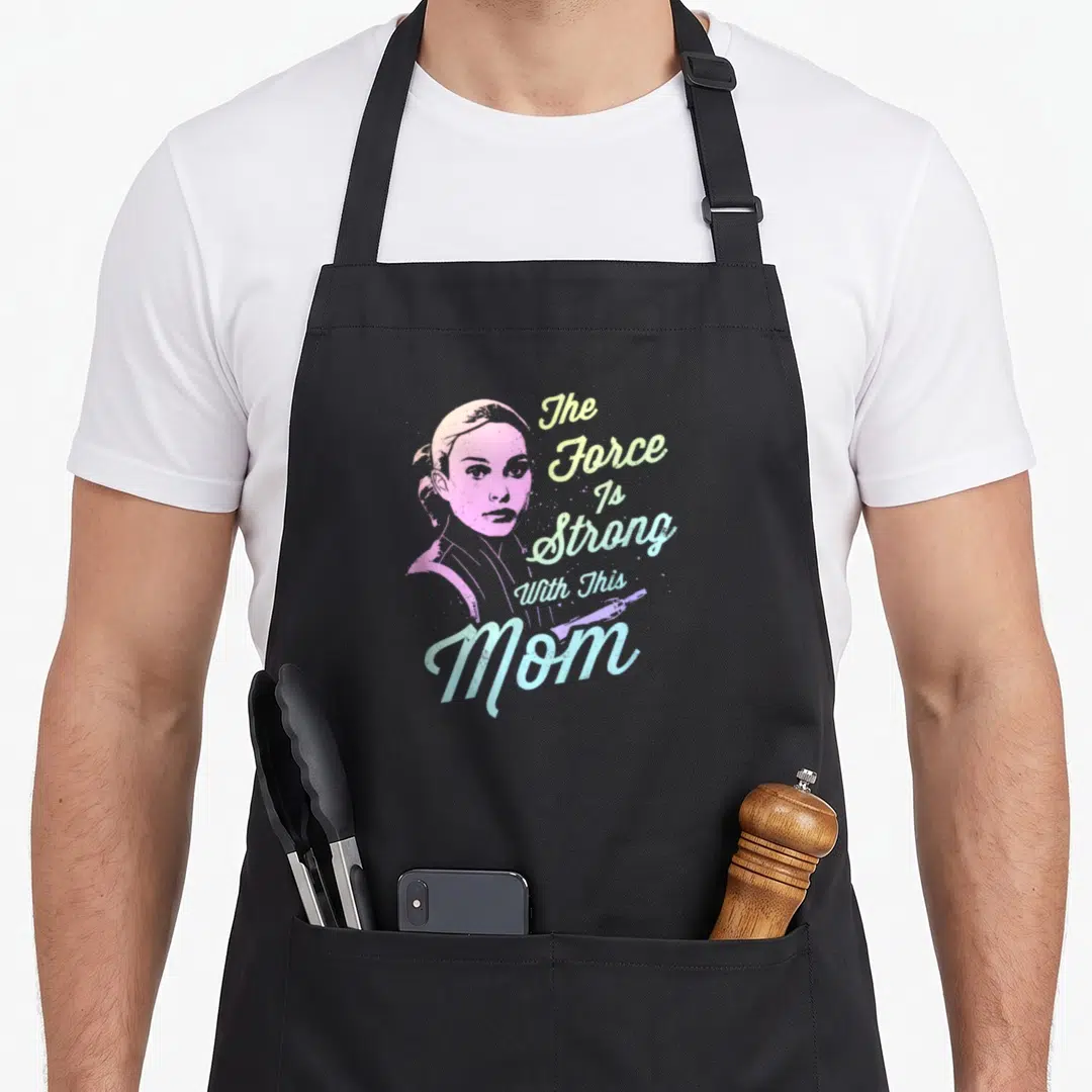 Padme mothers day apron - Pink woman portrait with The Force Is Strong With This Mom text and diagonal lightsaber — shown on a black cotton canvas apron against a white background