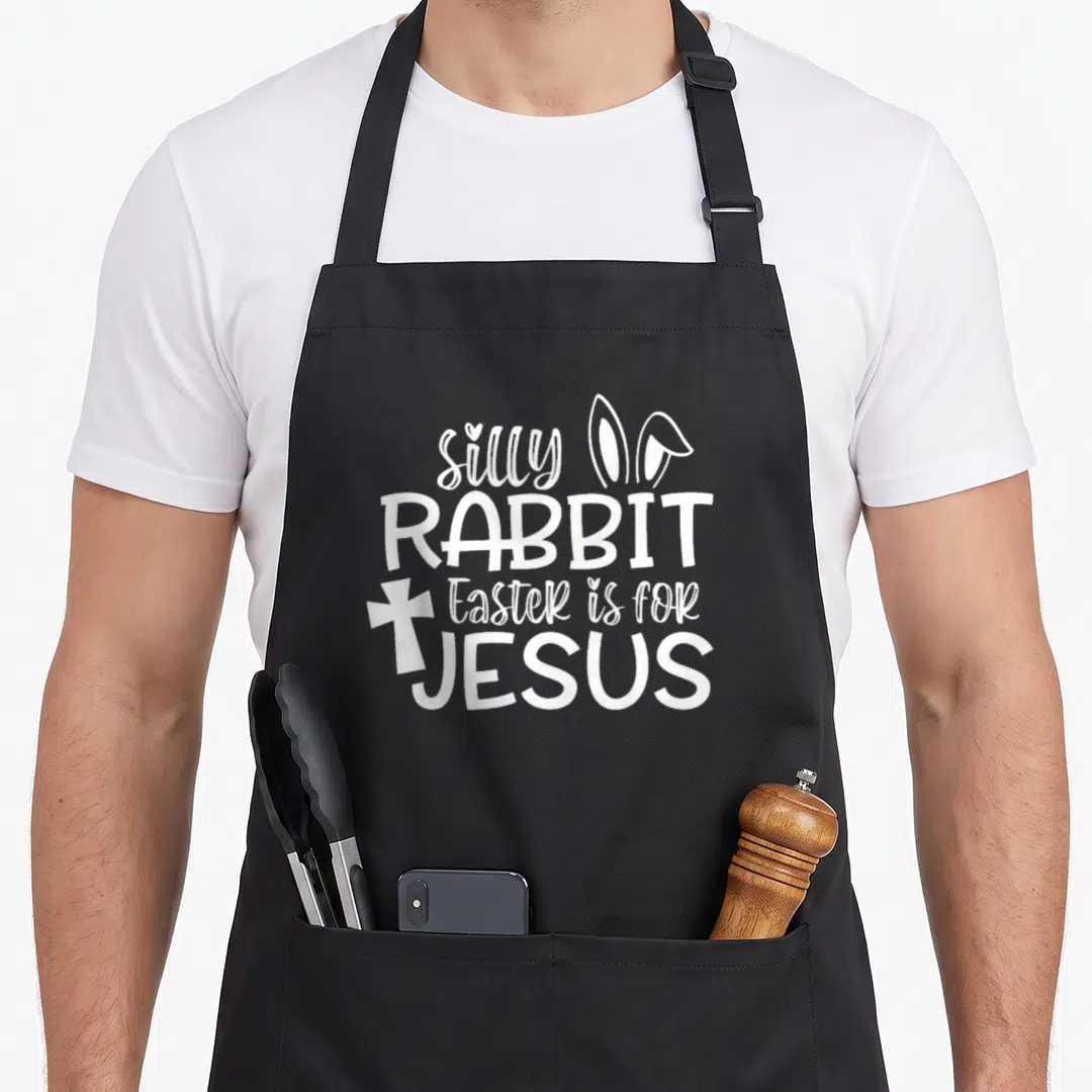 Christian silly rabbit apron - White stacked text reading silly RABBIT Easter is for JESUS with rabbit ears and cross — shown on a black cotton canvas apron against a white background