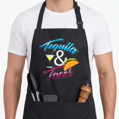Tequila taco mexican apron - Cartoon Tequila & Tacos text with cocktail glass and taco illustration in bright colors — shown on a black cotton canvas apron against a white background