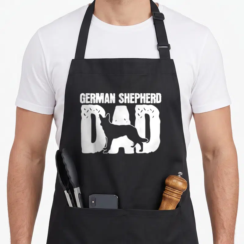 Father dog mom apron - White distressed text GERMAN SHEPHERD DAD with dog silhouette overlay — shown on a black cotton canvas apron against a white background