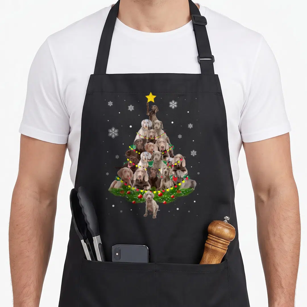 Weimaraner christmas tree apron - Pyramid of brown grey puppies with yellow star and lights on black apron — shown on a black cotton canvas apron against a white background
