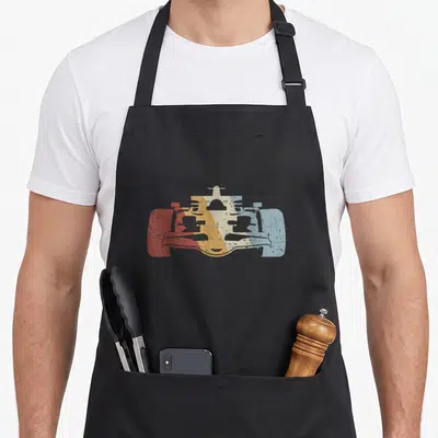 Motorsport car apron - Retro race car silhouette in red orange cream and blue on black fabric — shown on a black cotton canvas apron against a white background