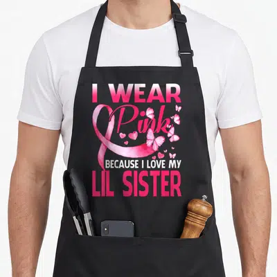 Lil breast cancer awareness aprons - Pink awareness ribbon with butterflies hearts and text about loving lil sister — shown on a black cotton canvas apron against a white background
