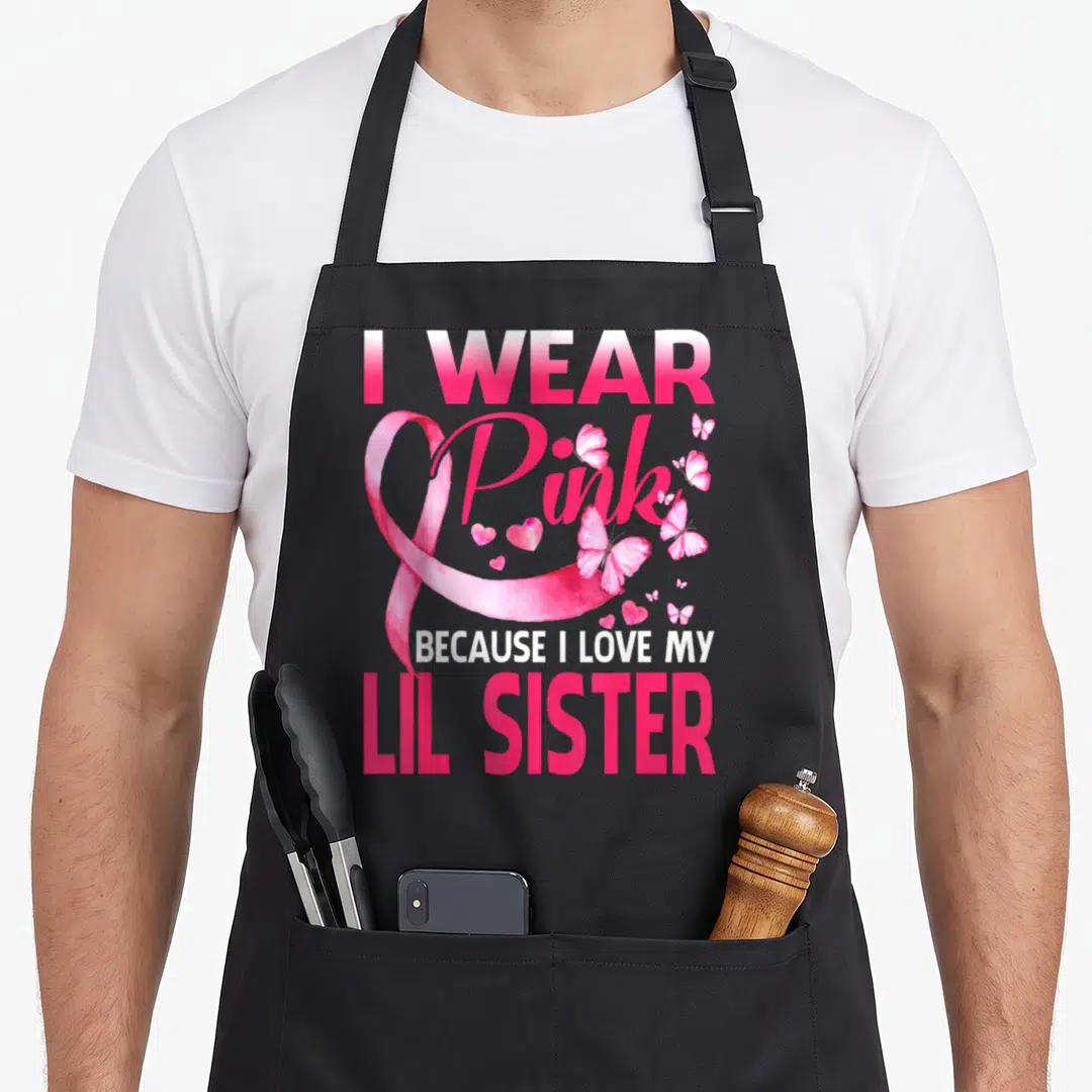 Lil breast cancer awareness aprons - Pink awareness ribbon with butterflies hearts and text about loving lil sister — shown on a black cotton canvas apron against a white background