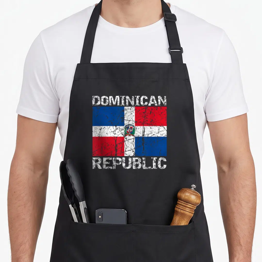 Dominican distressed apron - Distressed Dominican Republic flag print with DOMINICAN REPUBLIC text in red white blue — shown on a black cotton canvas apron against a white background