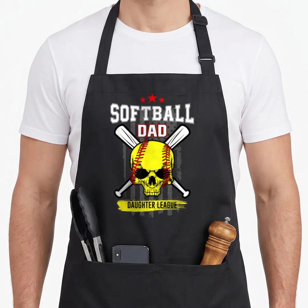 League dad and daughter aprons - Softball skull with crossed bats, three stars, and yellow brushstroke text — shown on a black cotton canvas apron against a white background