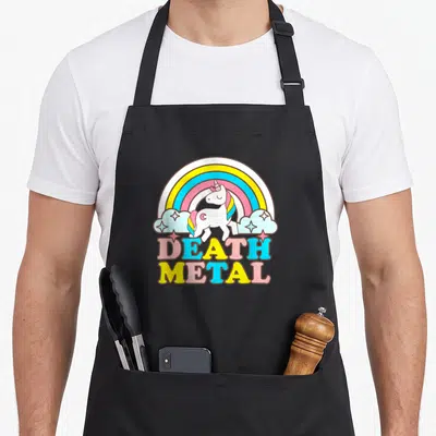 Metal rainbow apron - Cartoon unicorn under rainbow with multi-colored DEATH METAL text — shown on a black cotton canvas apron against a white background