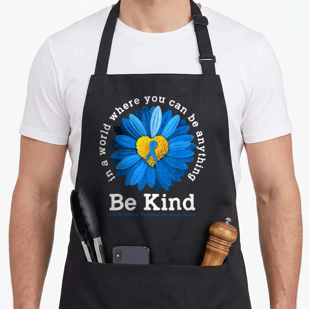 Blue sunflower apron - Blue flower with yellow center, blue ribbon, and text Be Kind Child Abuse Prevention Awareness — shown on a black cotton canvas apron against a white background