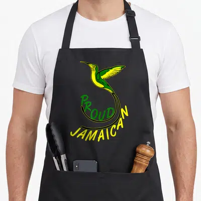 Jamaica doctor apron - Proud Jamaican hummingbird with curved green and yellow text — shown on a black cotton canvas apron against a white background