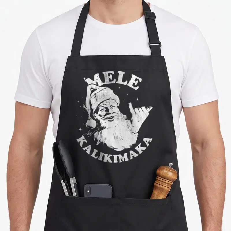 Surf christmas santa apron - White distressed Santa making shaka sign with Mele Kalikimaka text and stars — shown on a black cotton canvas apron against a white background