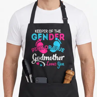 Godmother apron or apron - Pink and blue baby footprints with gender reveal text and hearts — shown on a black cotton canvas apron against a white background